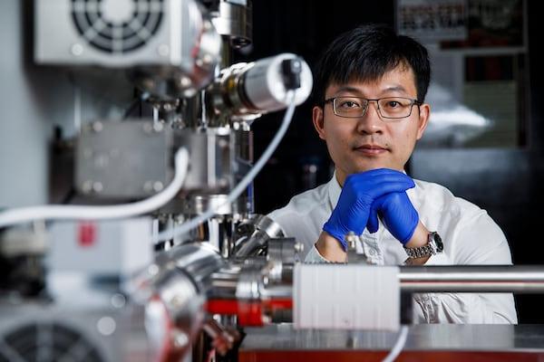 A student poses with lab equipment 